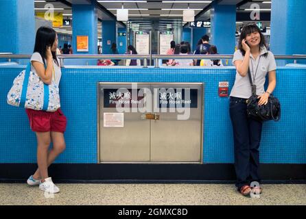 Hongkong, China - 28. Oktober 2006; zwei Mädchen plus Pendler in Schuss. Wie Mädchen auf der ganzen Welt gehen diese Teenager in Hongkong jetzt überall hin Stockfoto