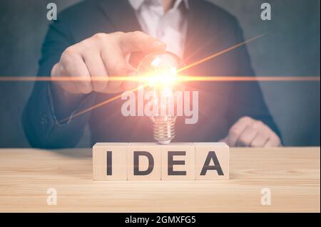 Geschäftsmann berührt eine helle Glühbirne. Konzept der Ideen für die Präsentation neuer Ideen große Inspiration und Innovation Neuanfang. Glühbirne für kreative Ideen Stockfoto