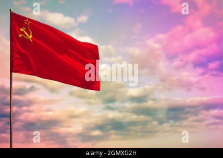 Flatterndes Modell der Flagge der Sowjetunion (SSSR, UdSSR) mit dem Platz für Ihren Text auf einem bunt bewölkten Himmel. Stockfoto