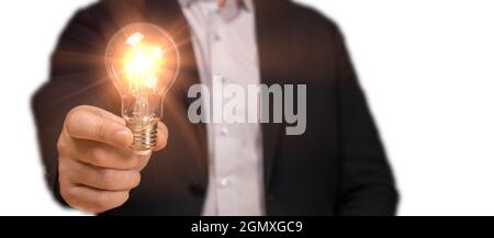 Idee Konzept mit Innovation und Inspiration. Geschäftsmann in Anzug hält Idee Glühbirne in der Hand isoliert auf weiß. Mann hält Glühbirnen, innovative tec Stockfoto