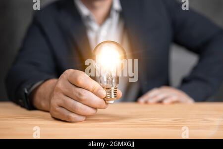 Mann hält Glühbirnen, Ideen für neue Ideen mit innovativer Technologie und Kreativität. Konzept Kreativität mit Glühbirnen, die Glanz Glitzer. Innovative te Stockfoto