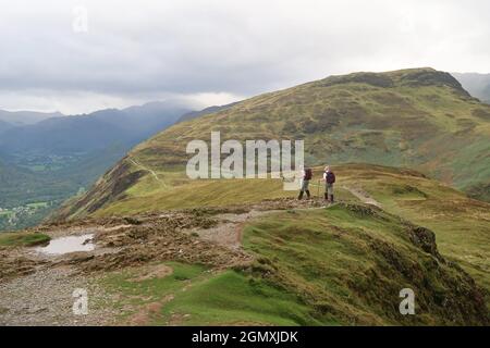 Ein älteres Paar geht den Ridge Path entlang Cat Bells, Lake District, Großbritannien. Erfahrene Wanderer mit passender Kleidung und Ausrüstung. Stockfoto