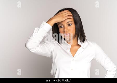 Besorgte Geschäftsfrau, die die Hand auf die Stirn hält, seufzend müde von Frustration über schlechte Nachrichten, Misserfolg Stockfoto