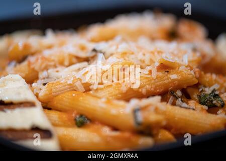 Nudeln mit Tomatensoße und Käse mit Basilikum auf einer hölzernen Hintergrund eingerichtet, Ansicht von oben Stockfoto