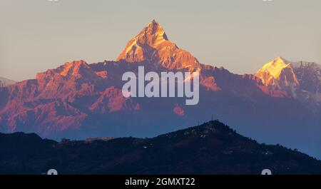 Rot gefärbte Sonnenuntergangsansicht des Mount Machhapuchhare, Annapurna Gegend, Nepal himalaya Stockfoto