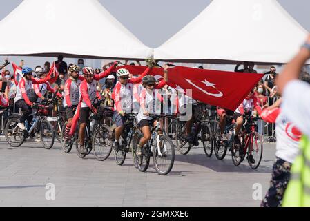 Izmir, Türkei - 9. September 2021: Fahrradfahrer-Gruppe, die eine riesige türkische Flagge von Afyon nach Izmir trägt, um dem Bürgermeister von Izmir Tunc als Geschenk zu geben Stockfoto