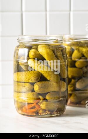 Kleine Gurken. Marinierte eingelegte Gurken im Glas auf dem Küchentisch. Stockfoto
