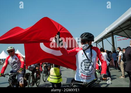 Izmir, Türkei - 9. September 2021: Fahrradfahrer-Gruppe, die eine riesige türkische Flagge von Afyon nach Izmir trägt, um dem Bürgermeister von Izmir Tunc als Geschenk zu geben Stockfoto