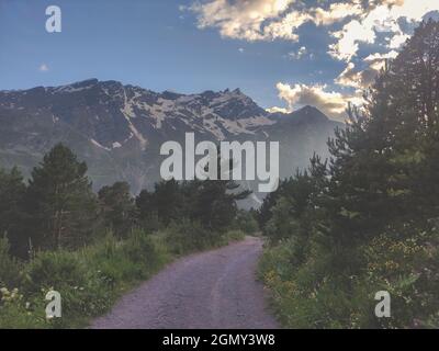 Eine unbefestigte Straße in den Bergen. Schöne Landschaft der Kaukasus-Berge bei Sonnenuntergang. Leere Wanderstraße. Stockfoto