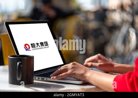 Antalya, Türkei - 21. September 2021: Logo des chinesischen Immobilienunternehmens Evergrande Real Estate Group auf dem Bildschirm des Computers der Frau. Stockfoto