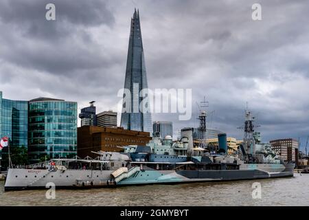 Die HMS Belfast liegt an der Themse vor dem Hintergrund des Shard, London, Großbritannien. Stockfoto