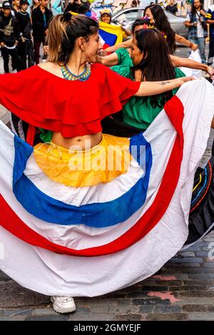 Kolumbianische Frauen tanzen in Einer Straße vor der Brick Lane als Teil Eines Protests gegen die kolumbianische Regierung, London, Großbritannien. Stockfoto