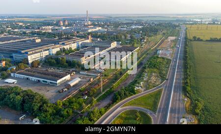 Luftdrohnenflug über Industriegebiet und Autobahn mit fahrenden Autos Stockfoto