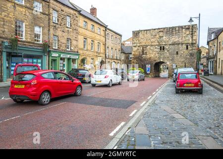 Fahrzeuge, die durch den schmalen Torbogen des Bondgate Tower in der Stadt Northumberland in Alnwick fahren. Stockfoto