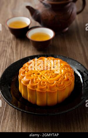 Mondkuchen mit chinesischem Tee. Das chinesische Schriftzeichen auf dem Mondkuchen stellt auf Englisch die „Pandan Lotus Paste“ dar Stockfoto