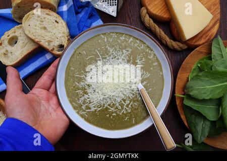 Grüner Frühling, sommerliche gesunde Sahnesuppe aus Sauerampfer mit Parmesankäse, köstliches hausgemachtes Abendessen Stockfoto