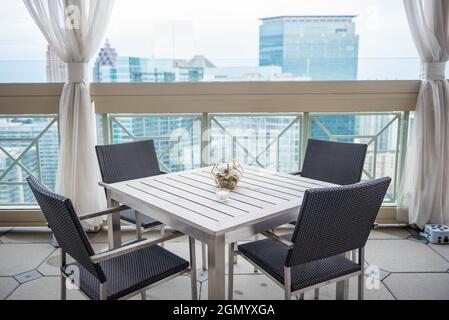 Horizont-Aufnahme eines Tisches mit vier Stühlen im Balkon, aufgenommen im Peachtree Club in Atlanta, GA Stockfoto