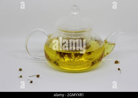 Kamillenblüten brauen in heißem Wasser. Kräutertee mit Kamille für beruhigende Wirkung. Stockfoto