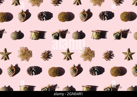 Trendiges Muster aus goldenen Kugeln auf rosa Hintergrund. Weihnachtskonzept. Stockfoto