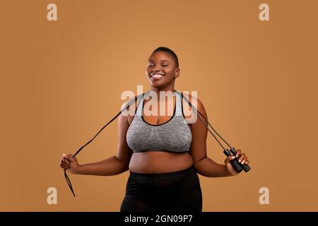 Black Chubby Frau Posiert Mit Springseil Im Studio Stockfoto