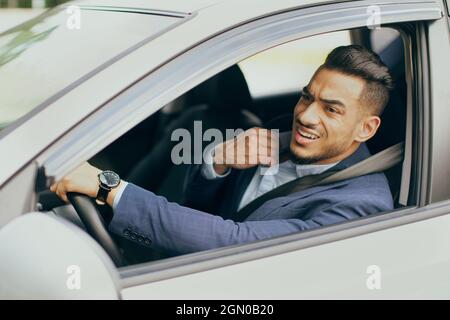 Nervöser Fahrer, der im Auto sitzt und im Verkehr festsitzt Stockfoto