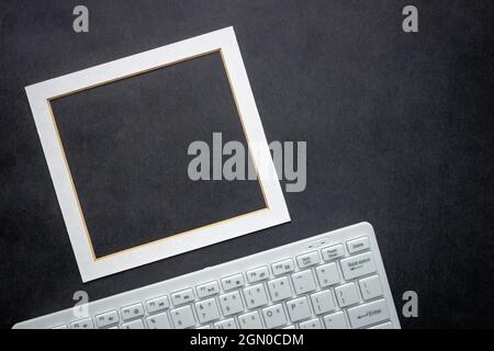 Weiße Computertastatur und ein Rahmen für Ihren eigenen Text, schwarzer Hintergrund, Business Concept Stockfoto