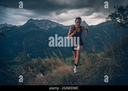 Die junge Frau läuft in der Abendstimmung in Falkenstein, Allgäu, Bayern, Deutschland Stockfoto