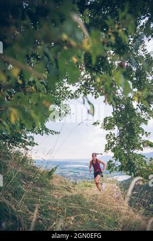 Die junge Frau läuft in der Abendstimmung in Falkenstein, Allgäu, Bayern, Deutschland Stockfoto