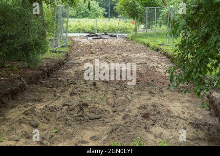 Vorbereitung auf der Baustelle für die Verlegung von Pflasterplatten. Bau eines Bürgersteiges in einem Stadtpark Stockfoto
