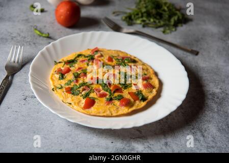 Bereit, Kräuter gefüllt Omelette in einem Teller zu essen. Draufsicht. Stockfoto