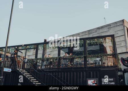 London, Großbritannien - 03. September 2021: Blick von der Straße der Menschen auf dem Dach Café im BOXPARK Shoreditch, Transportcontainer, Pop-up-Mall für unabhängige Stockfoto