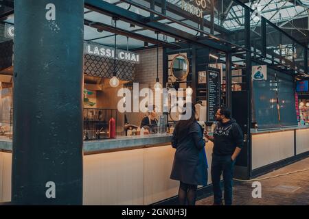 London, Großbritannien - 03. September 2021: Menschen am Indi-Go Street Food Stall im Spitalfields Market, einer der schönsten erhaltenen viktorianischen Markthallen Stockfoto