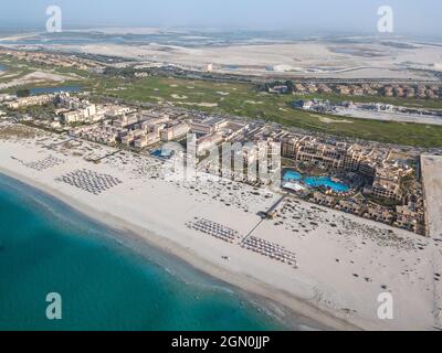 Luftaufnahme von Saadiyat Rotana Resort & Villas (rechts) und anderen Strandhotels mit Strand und Meer, Saadiyat Island, Abu Dhabi, Vereinigte Arabische Emirate, Mi Stockfoto