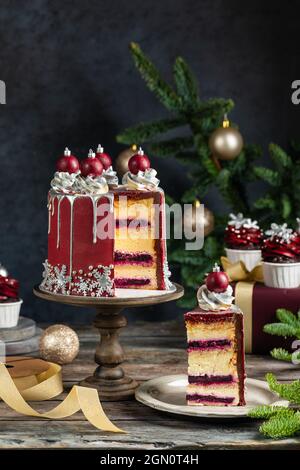 Große Weihnachts-Neujahrs-Weihnachtskuchen mit süßen Bällen und Schneeflocken, Cupcakes und Muffins auf rustikalem Hintergrund, Postkarte oder Einladungswagen dekoriert Stockfoto