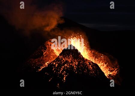 Eruption am Fagradalsfjall, Island. Glühende Lava wird aus dem vulkanischen Schlot ausgebrochen. Nachts aufgenommen, ist die Lava auf schwarzem Hintergrund isoliert. Stockfoto