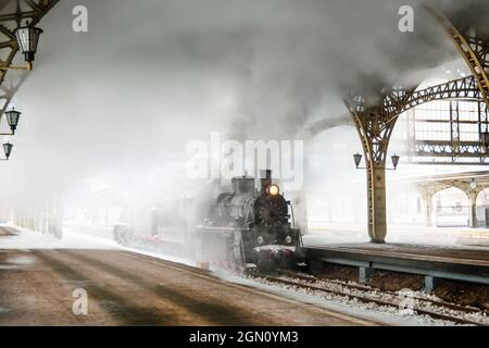 Dampflokomotive steht auf der Plattform des Bahnhofs, Winter kalt verschneiten Tag Stockfoto