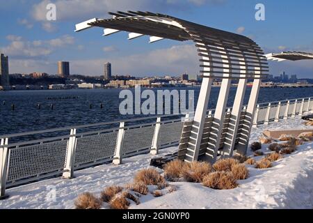 Eine spektakuläre Bank, um den Blick auf den Fluss mit dem Schnee im Riverside Park zu genießen Stockfoto