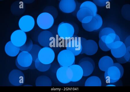 Defokussed Lichter. Blaues Bokeh auf schwarzem Hintergrund. Overlay zu Weihnachten und Neujahr. Speicherplatz kopieren Stockfoto