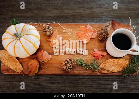 Herbstliche Herbstsaison – Konzept von oben Tischdekor mit Kaffee, Laub, Kürbissen und Buchstaben, die den Herbst buchstabieren Stockfoto