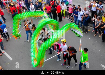 Der liong oder grüne Drache, der sich seinen Weg bahnt, gespielt von seinen Trägern mit langen Stöcken, mitten im Publikum während des Cap Go Meh Karnevals. Stockfoto