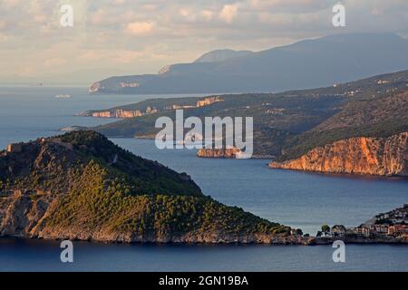 Blick über die zerklüftete Westküste nach Norden, im Vordergrund die Stadt Assos mit ihrer Burg, Kefalonia Island, Ionische Inseln, Griechenland Stockfoto
