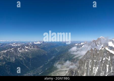 Luftaufnahme von der aiguille du Midi auf die europäischen Alpen und Chamonix in der Ferne. Schneebedeckte Bergketten Stockfoto