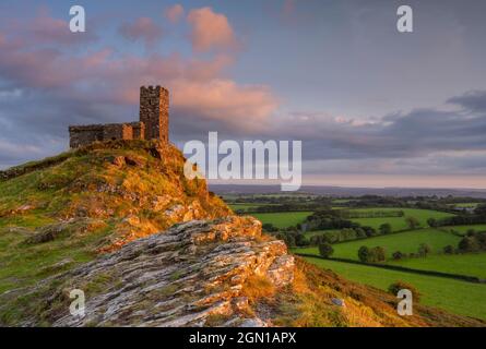 Brent Tor; Dartmoor National Park, Devon, Großbritannien. September 2021. UK Wetter: St Michael de Rupe Church und Brent Tor, leuchten mit goldener Abendfarbe, wenn die Sonne über der wunderschönen West Devon Landschaft untergeht. Kredit: Celia McMahon/Alamy Live Nachrichten Stockfoto