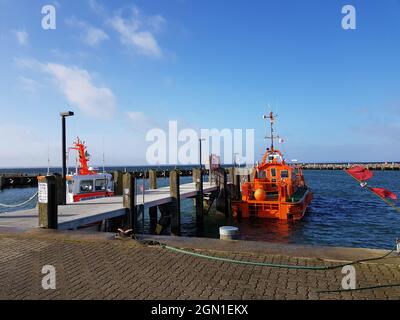 Orange Motorboot in der Nähe der Seebrücke in der Ostsee, Poel Insel an einem sonnigen Tag Stockfoto