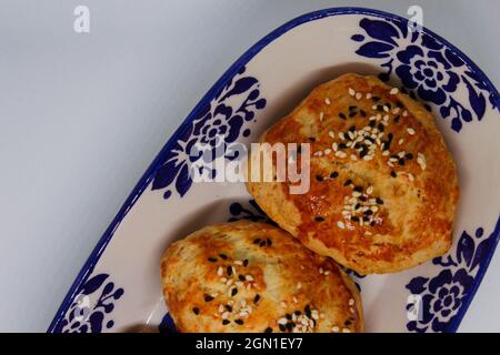 Türkisches Gebäck, das von Großmutter hergestellt wurde. Frisch gebackenes Gebäck mit Käsefüllung. Backwaren im Ofen. Stockfoto