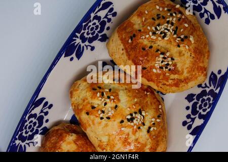 Türkisches Gebäck, das von Großmutter hergestellt wurde. Frisch gebackenes Gebäck mit Käsefüllung. Backwaren im Ofen. Stockfoto