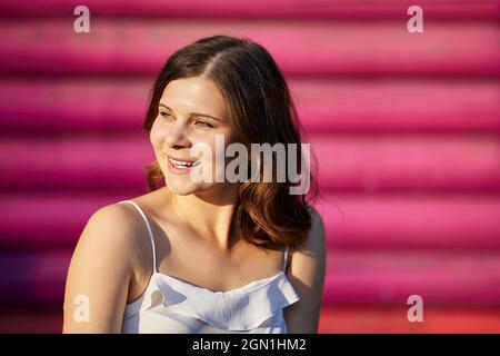 Porträt einer lächelnden weißen Frau mit Blockhaus auf dem Hintergrund. Stockfoto