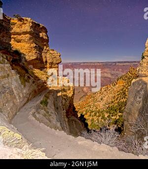 Grand Canyon bei Nacht vom oberen South Kaibab Trail. Flash wurde für den Vordergrund verwendet. Die Klippen und der Canyon sind von Mondlicht beleuchtet. Stockfoto