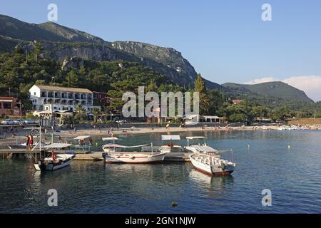 Der Strand von Agios Spiridon in Paleokastritsa liegt zwischen zwei Halbinseln. Ausflugsboote starten vom Pier, Korfu Insel, Ionische Inseln, Gr Stockfoto