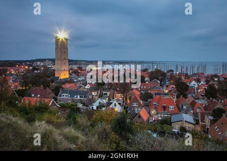 Leuchtturm Terschelling und Stadt mit Yachthafen in der Dämmerung vom Hügel aus gesehen, West Terschelling, Terschelling, Westfriesische Inseln, Friesland, Niederlande Stockfoto